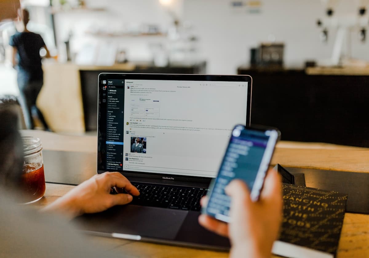 A laptop and phone open to a customer conversation